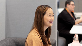 Masasında gülümseyen bir kadın çalışan