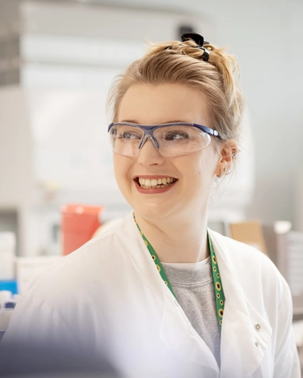 Gülümseyen bir laboratuvar çalışanı