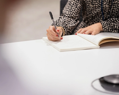 Defterine yazı yazan bir kadının elleri