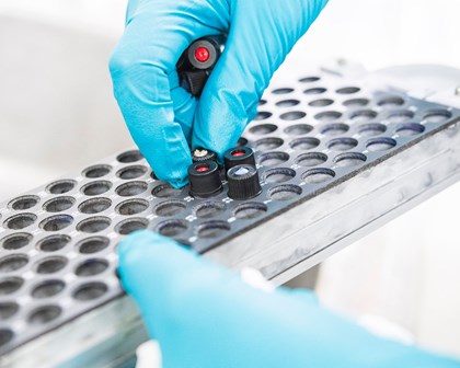 Test tüplerini yerleştiren mavi eldivenli bilim insanı 