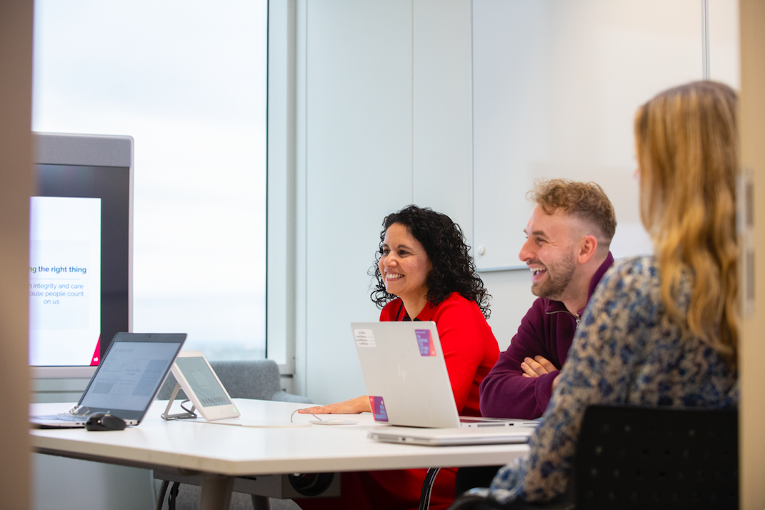 Masa başında toplantı yapan üç kişi