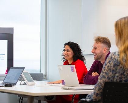 Masa başında toplantı yapan üç kişi